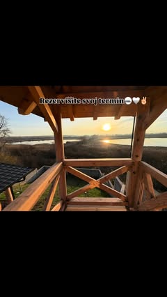 Zalazak sunca nad jezerom kroz drvenu konstrukciju terase