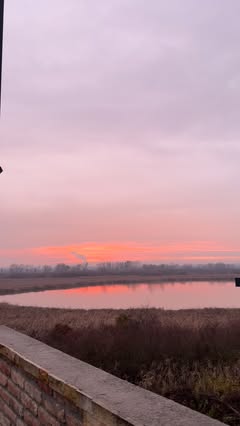 Ružičast zalazak sunca nad jezerom, pogled sa terase